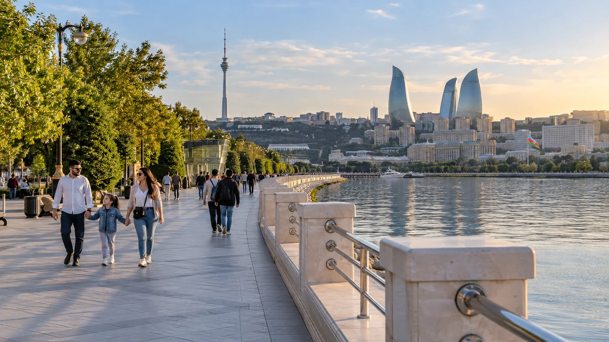 People walking along the tree-lined seafront boulevard in Baku with the Flame Towers in the distance
